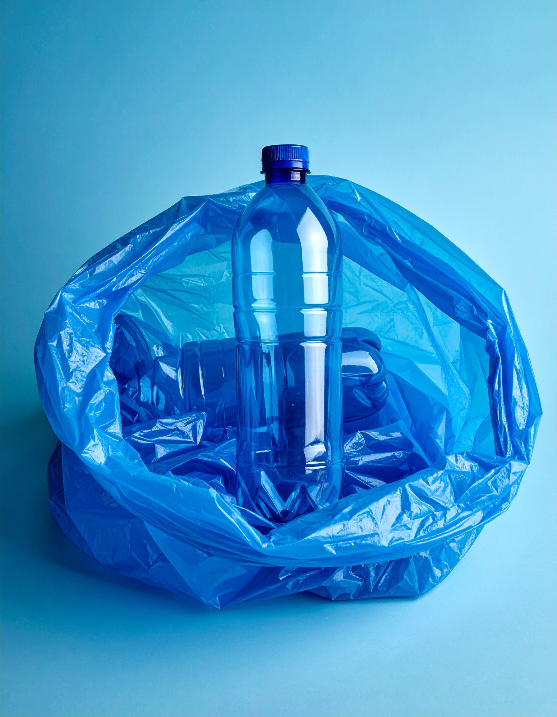 Firefly_blue plastic bottles inside a blue plastic bag; blue backgound 680400